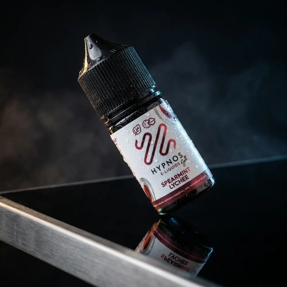 Garrafa Liquido Hypnos Salt Spearmint Lychee 30ml em estúdio luxuoso sobre acrilico, gotas e reflexo - Vapor Gringo