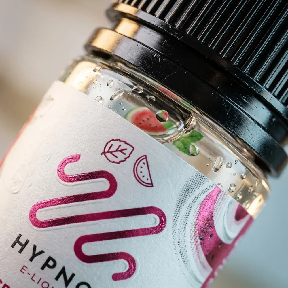 Close-up do rótulo e bico do Liquido Hypnos Salt Spearmint Watermelon 30ml com gotículas e textura do vidro - Vapor Gringo