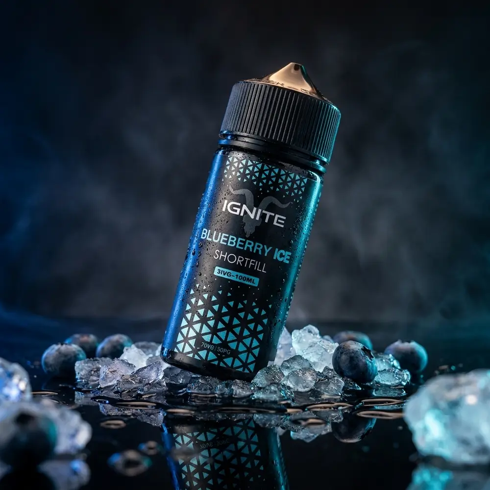 Frasco 100ml Liquido Ignite Blueberry Ice sobre acrilico preto com mirtilos, gelo e condensacao, iluminacao fria - Vapor Gringo