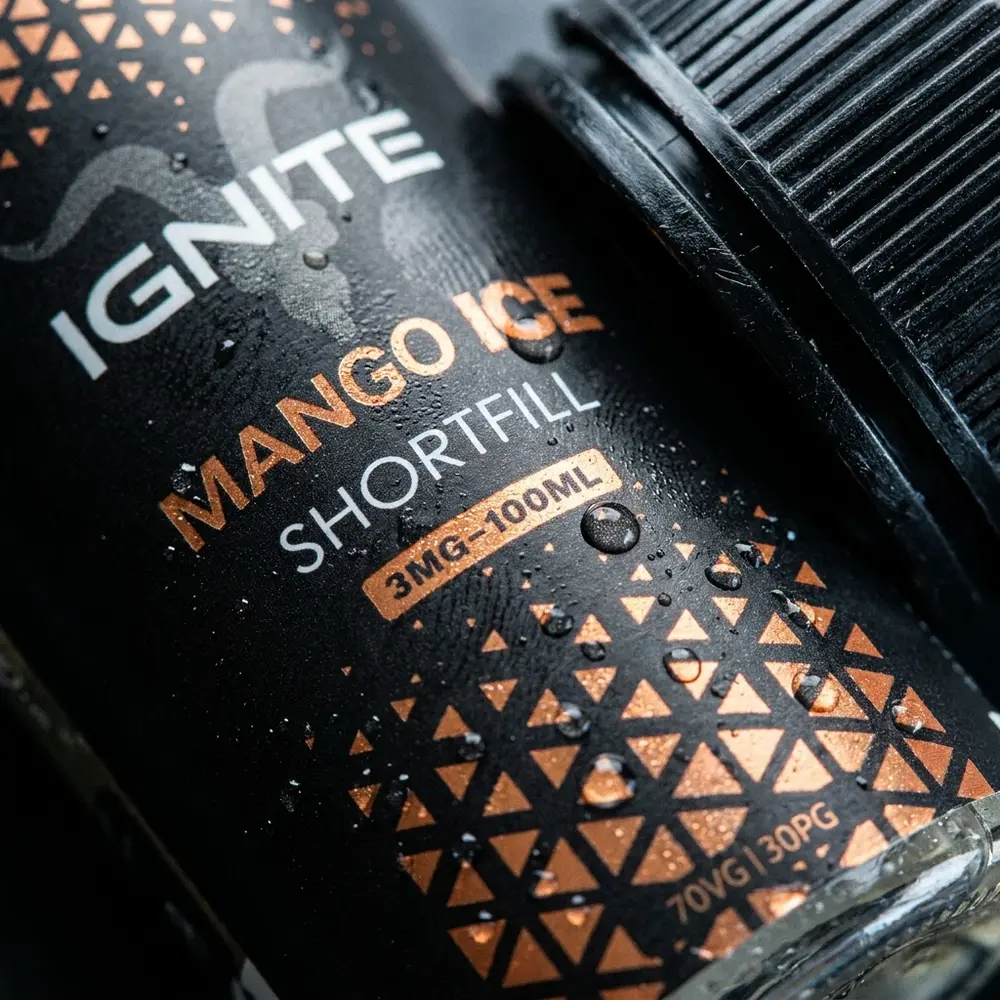 Rótulo do Líquido Ignite Mango Ice em detalhe, gotículas de condensação sobre o vidro e textura do rótulo - Vapor Gringo