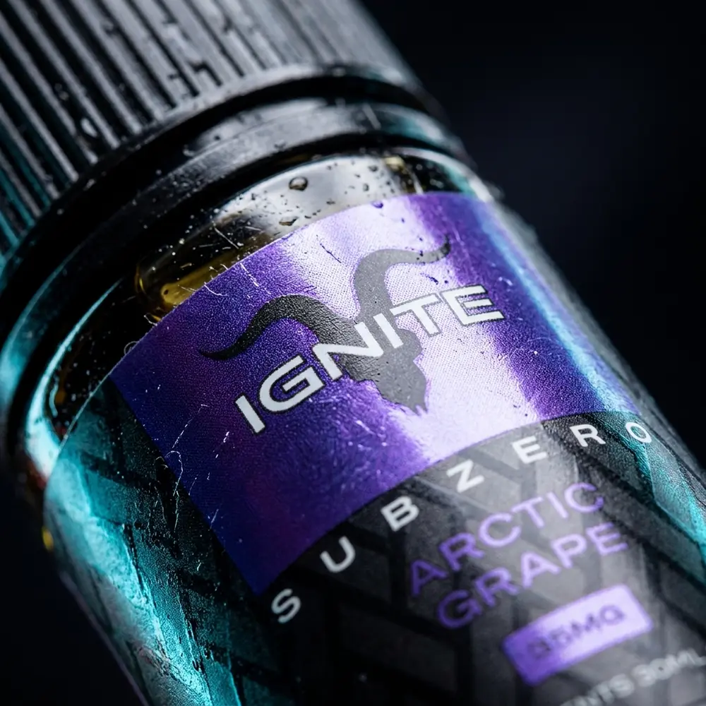 Detalhe do rótulo Líquido Ignite Salt Arctic Grape com gotas de condensação, textura do rótulo e reflexos metálicos - Vapor Gringo