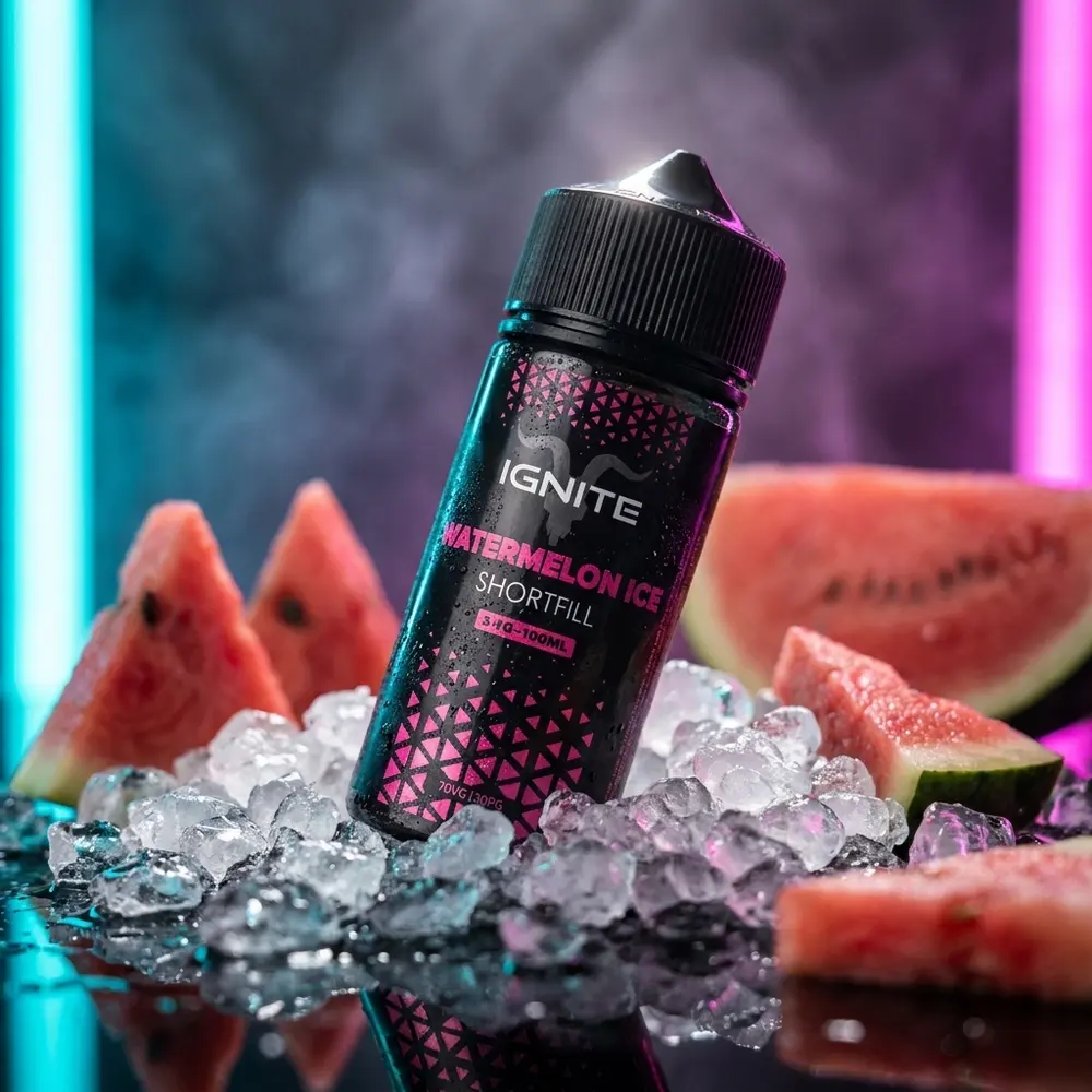Garrafa Liquido Ignite Watermelon Ice apoiada em acrilico molhado com fatias de melancia e gelo, luzes cyan-magenta. - Vapor Gringo
