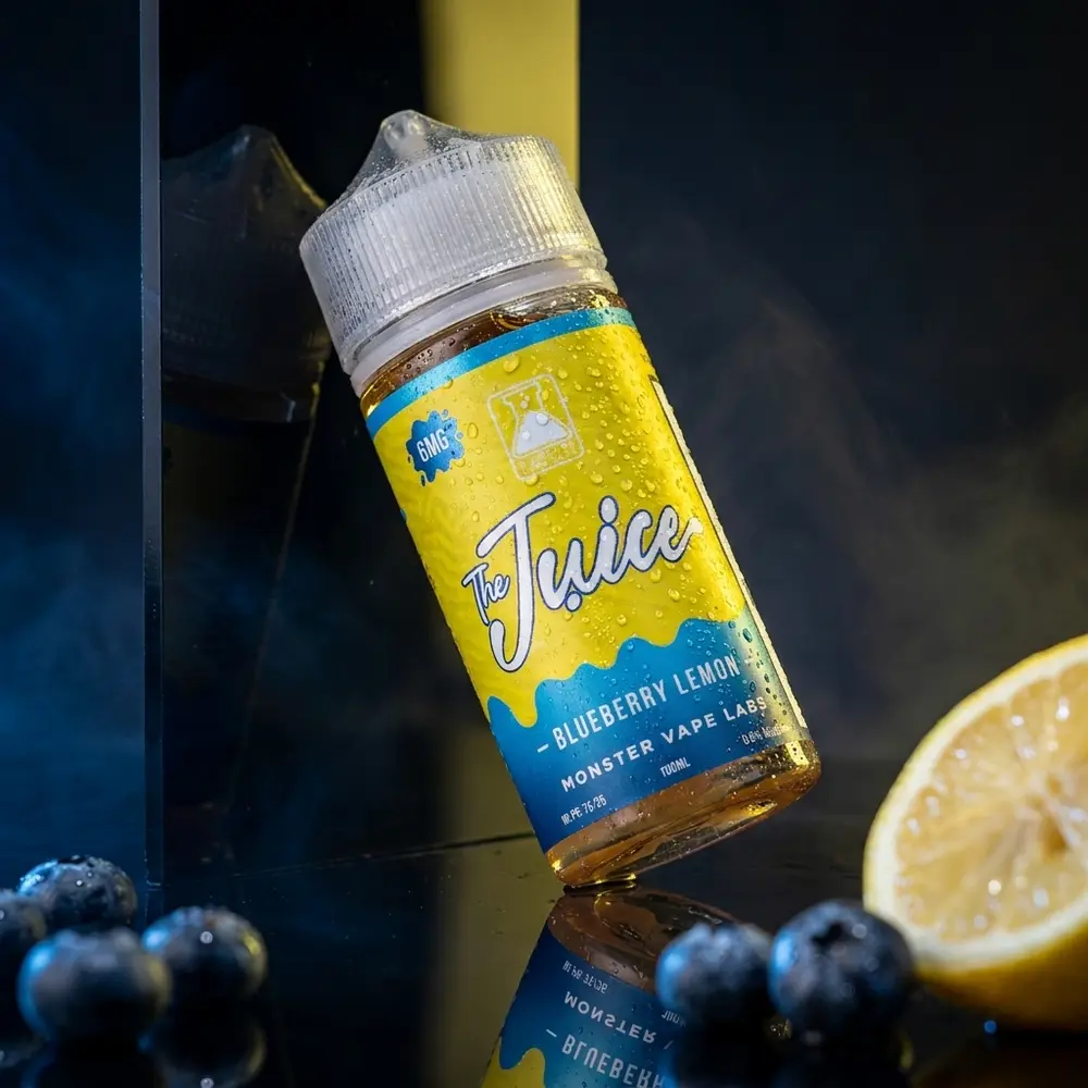 Garrafa de líquido Jam Monster Blueberry Lemon sobre base acrílica molhada, condensação e luzes azul e amarelo - Vapor Gringo