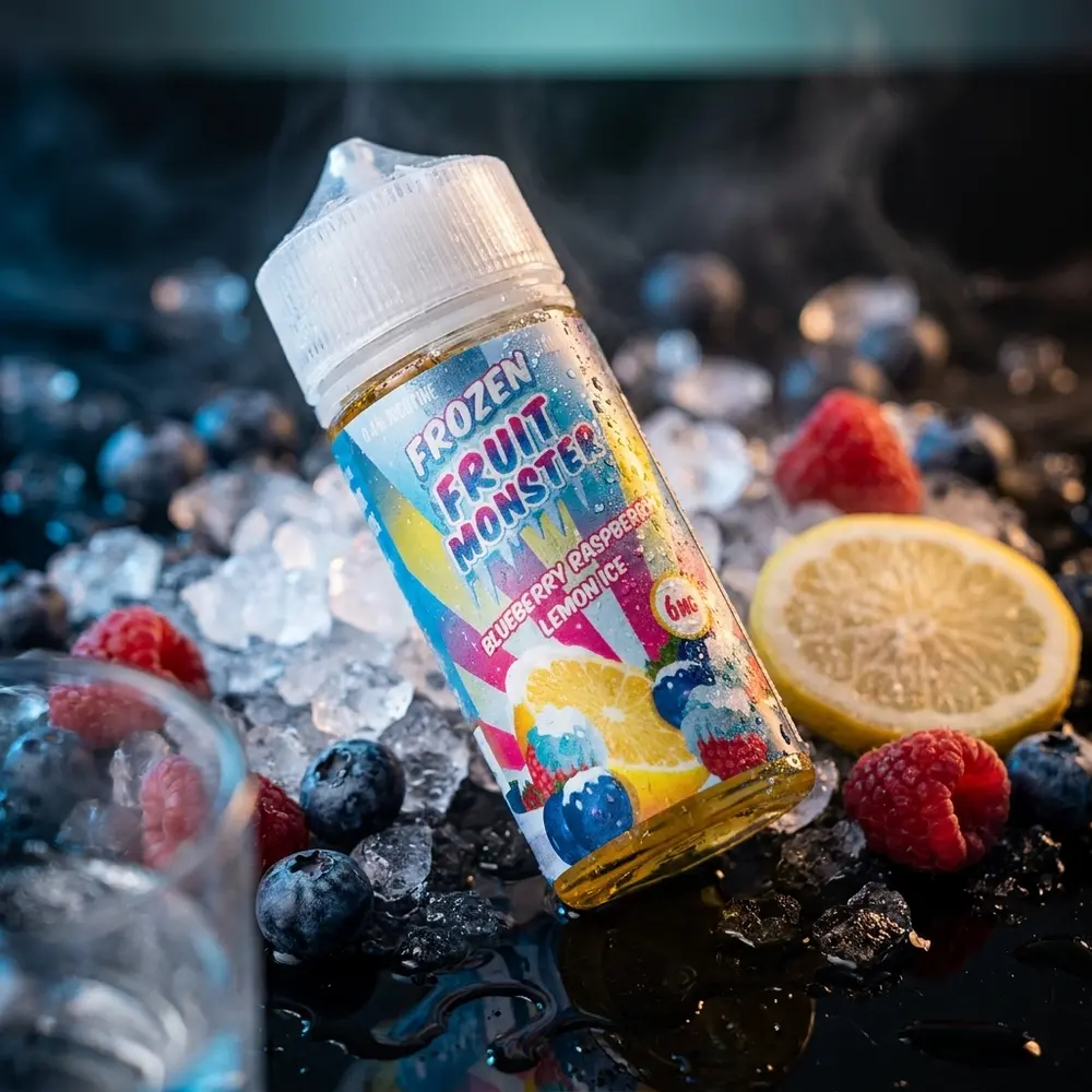Frasco liquido Jam Monster Frozen Fruit Monster sobre acrilico preto com gelo, mirtilos e reflexos azuis - Vapor Gringo
