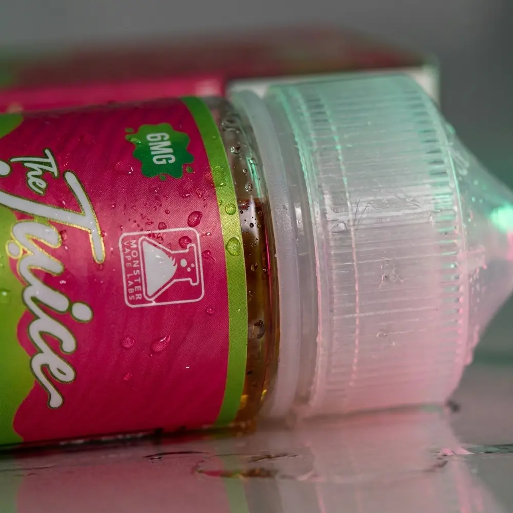 Detalhe do bocal e do rotulo do Liquido Jam Monster Watermelon Lime com gotas de condensacao e reflexos - Vapor Gringo