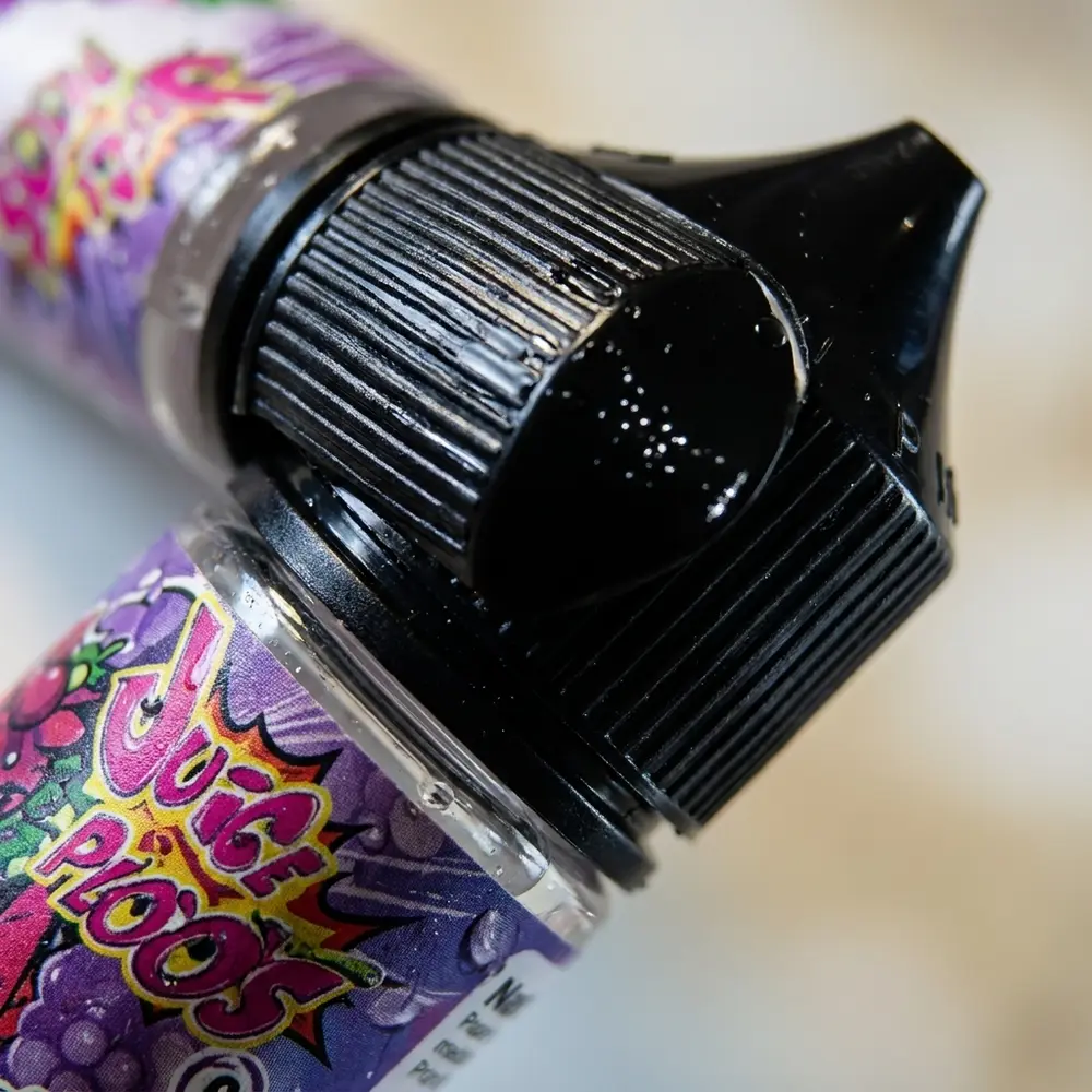 Close-up do rótulo e bico do Juice Ploos Bubalo de Morango com condensação e reflexos metálicos - Vapor Gringo