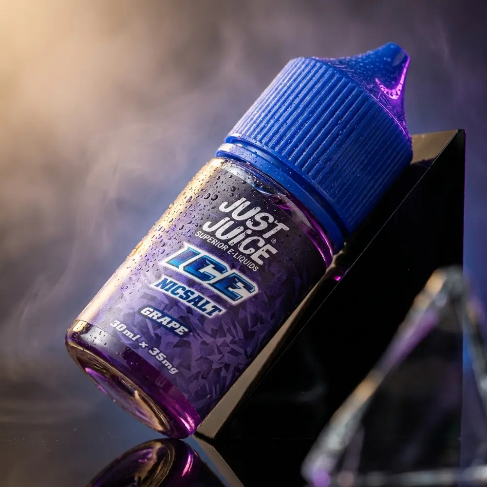 Garrafa Just Juice Salt Grape Ice em estúdio escuro com condensação e reflexos roxos, rótulo visível - Vapor Gringo