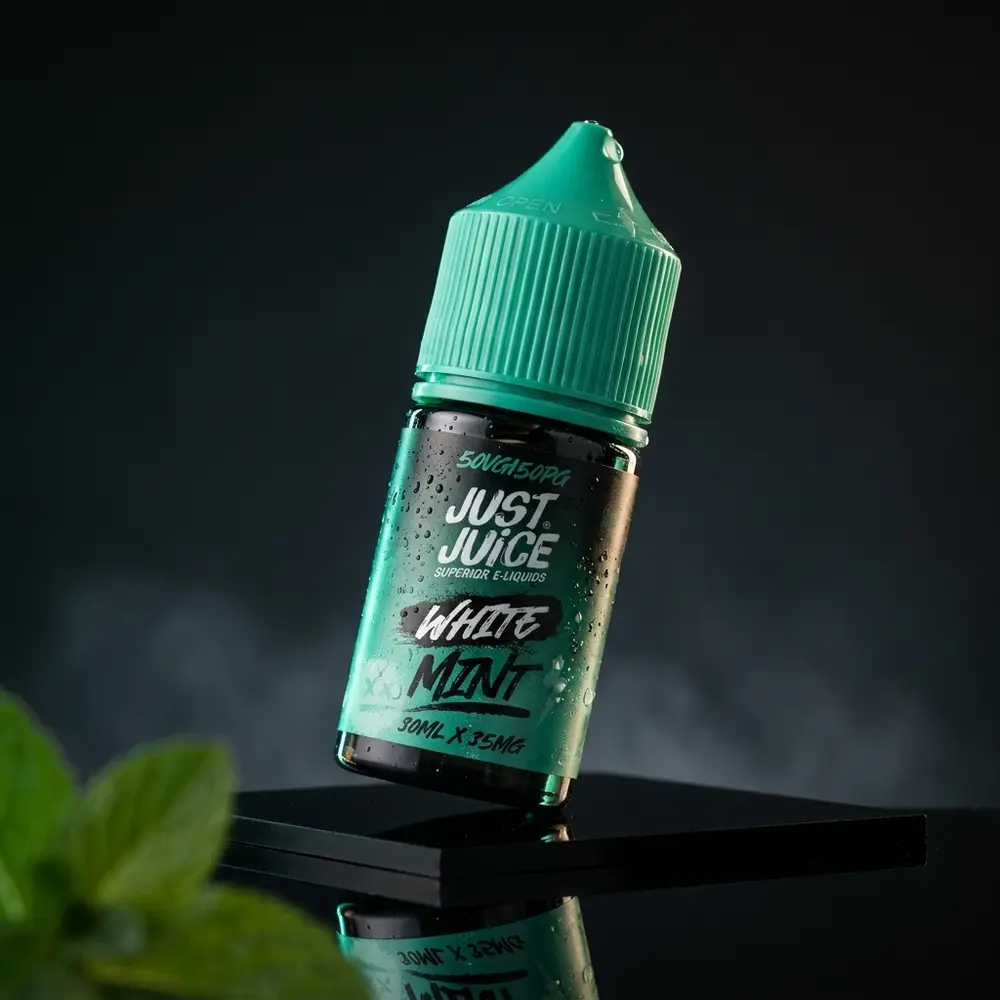 Garrafa Líquido Just Juice Salt White Mint em estúdio sobre acrílico preto com condensação - Vapor Gringo