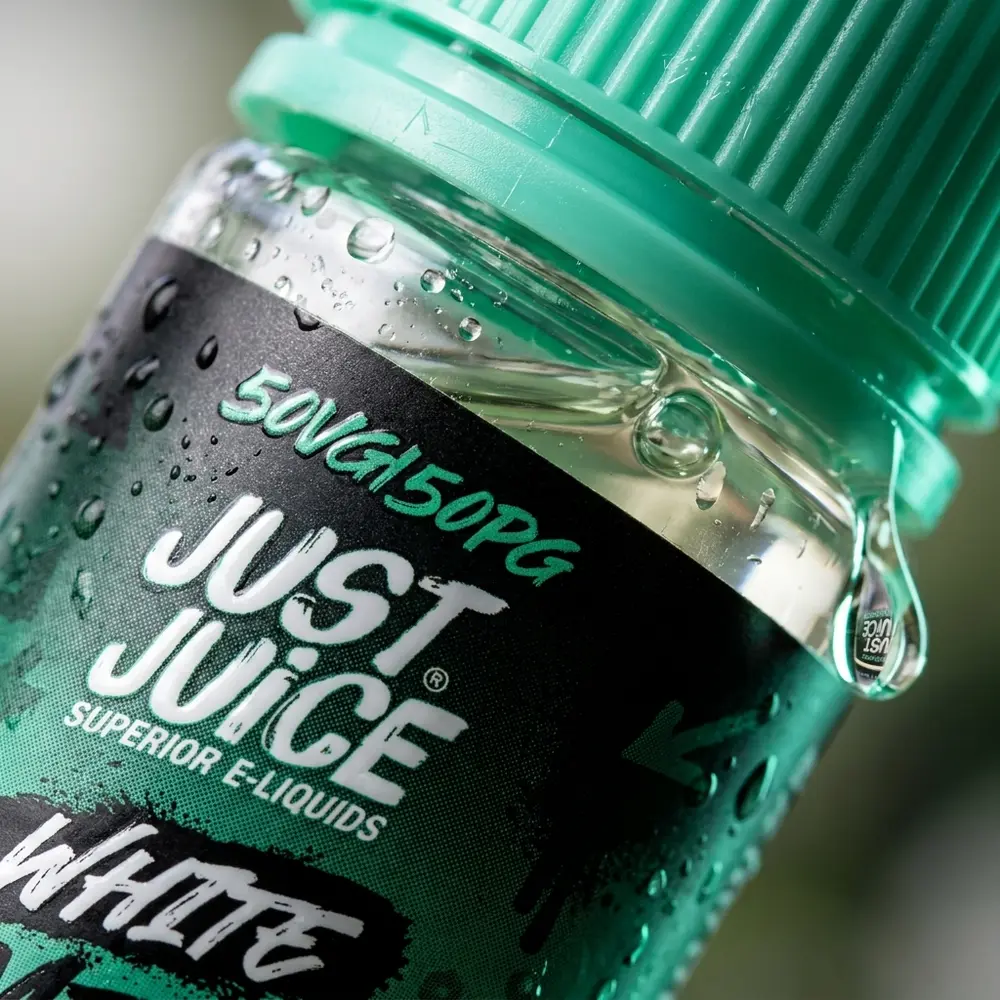 Macro do rótulo e bico da Just Juice White Mint com gota e microcondensação visíveis - Vapor Gringo