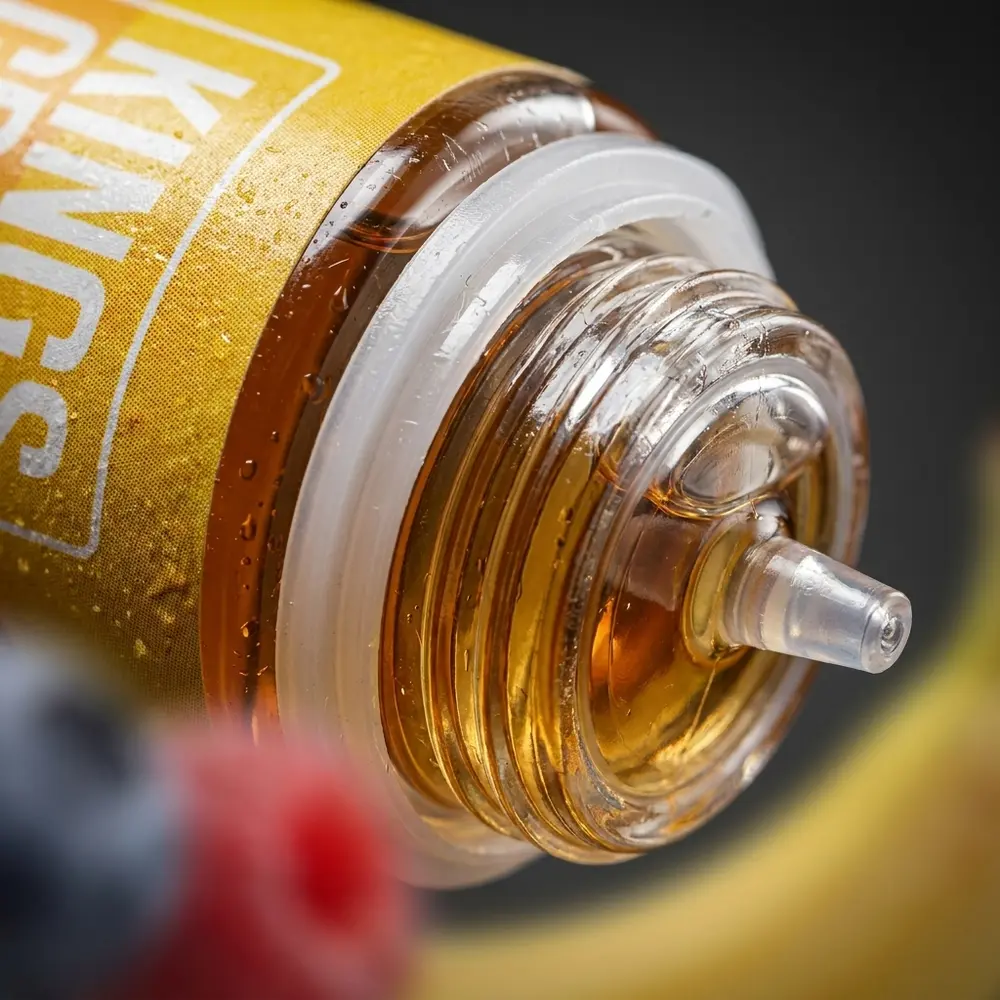 Detalhe do rótulo e bocal do líquido Kings Crest Banana Berry Ice, gotas de condensação e textura do vidro - Vapor Gringo