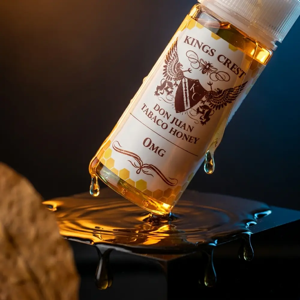 Garrafa Kings Crest Don Juan Tabaco Honey 120ml sobre acrilico preto com reflexos ámbar e gotas de mel - Vapor Gringo
