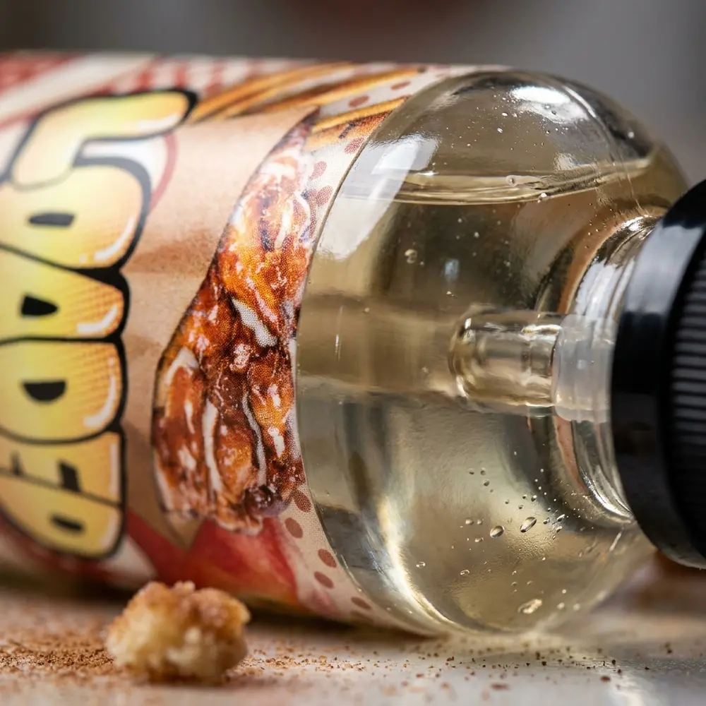 Close macro do rótulo Loaded Apple Fritter com gotas, textura do vidro e detalhe do bocal. - Vapor Gringo