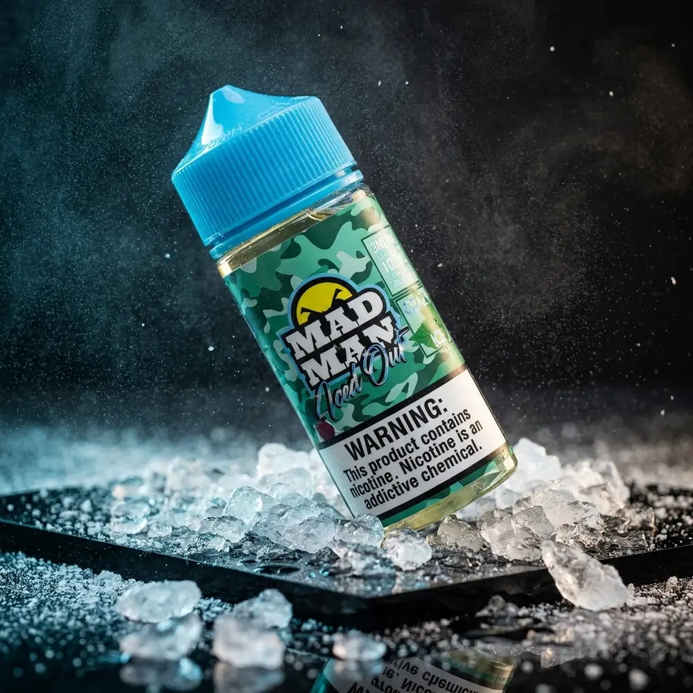 Frasco do liquido Mad Man Crazy Iced Out Spearmint sobre acrilico preto com gelo, nevoa e reflexos frios - Vapor Gringo
