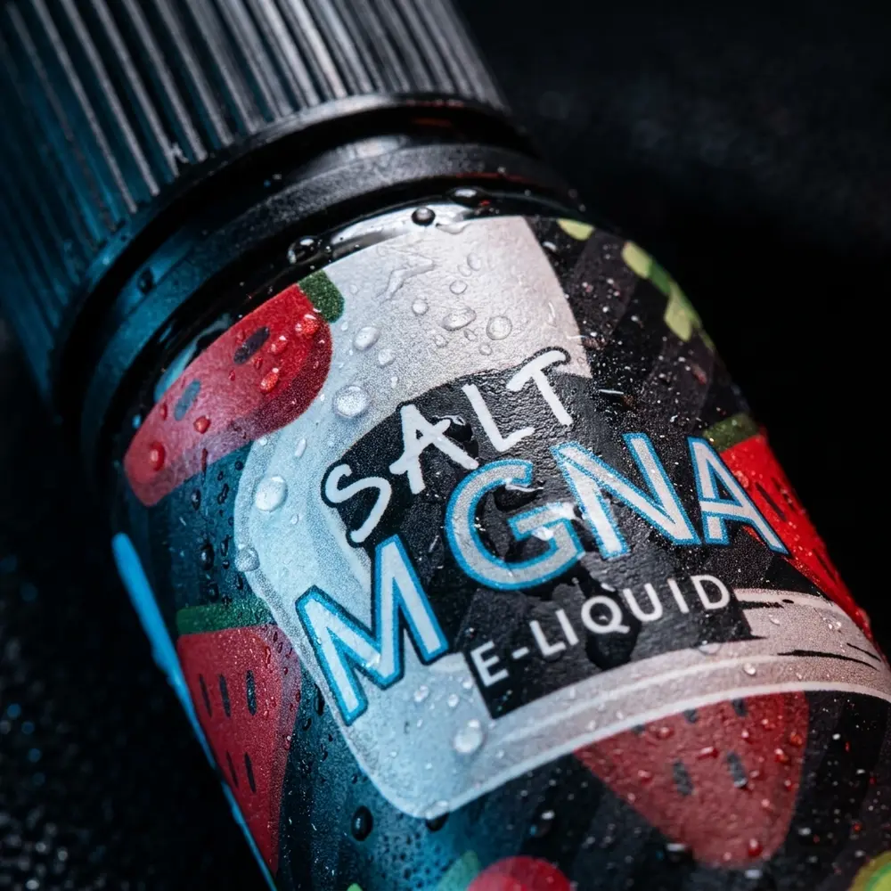 Macro do rótulo e tampa do Líquido Magna Cranberry Punch Ice mostrando gotículas, textura do rótulo e reflexos. - Vapor Gringo