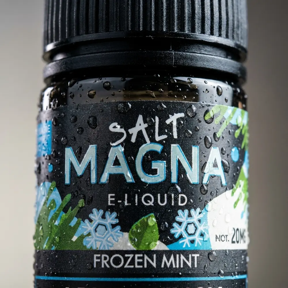 Close no rótulo e bocal da garrafa Magna Frozen Mint com gotas de condensacao e textura detalhada do rótulo - Vapor Gringo