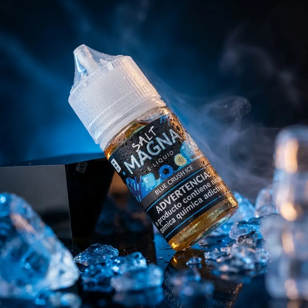 Garrafa do Liquido Magna Salt Ice Blue Crush Ice inclinada sobre acrilico preto, com cristais de gelo e gotas de condensacao - Vapor Gringo