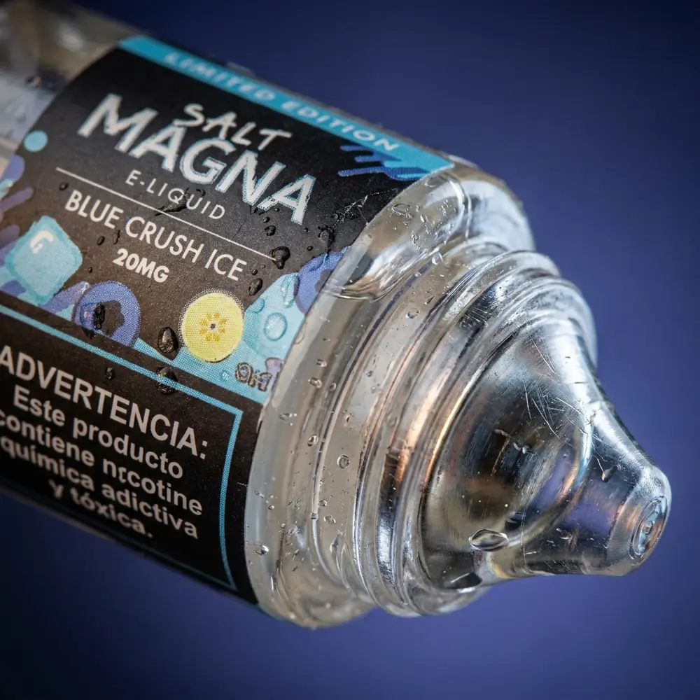 Macro do rotulo e bico do Liquido Magna Salt Ice Blue Crush Ice com gotas de condensacao e textura nítida - Vapor Gringo