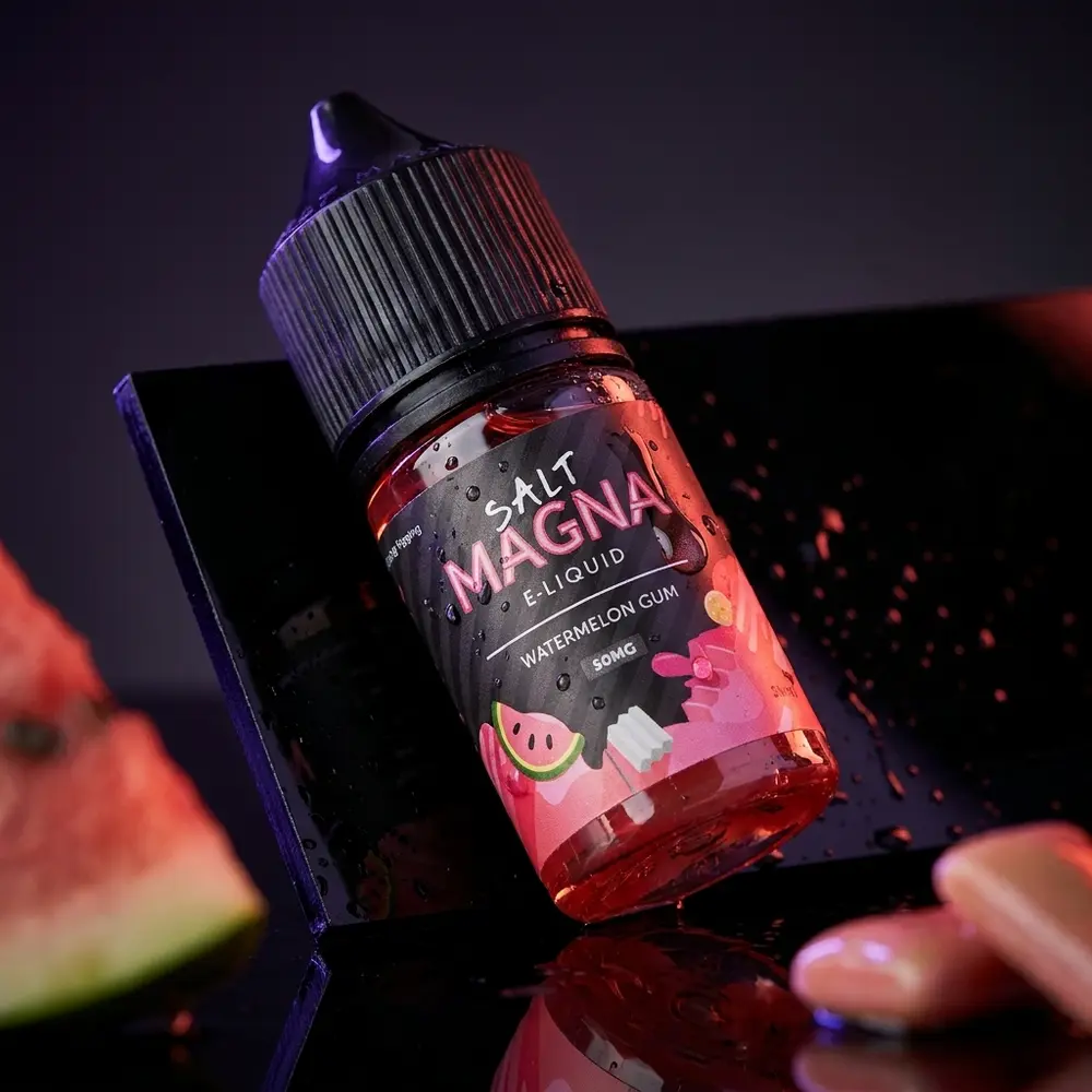 Garrafa Liquido Magna Salt Watermelon Gum sobre acrilico preto molhado com luzes vermelha e roxa - Vapor Gringo
