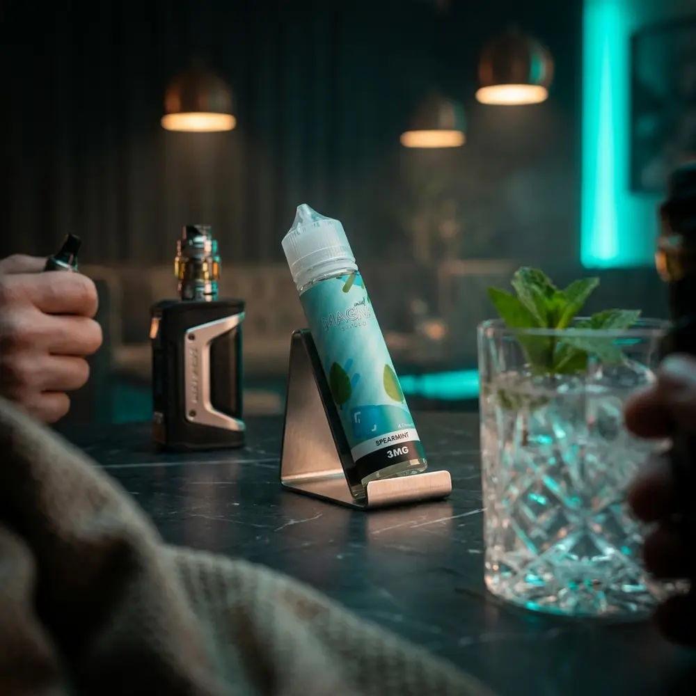 Garrafa Liquido Magna Spearmint em lounge de luxo sobre tampo de marmore com folhas de hortela - Vapor Gringo
