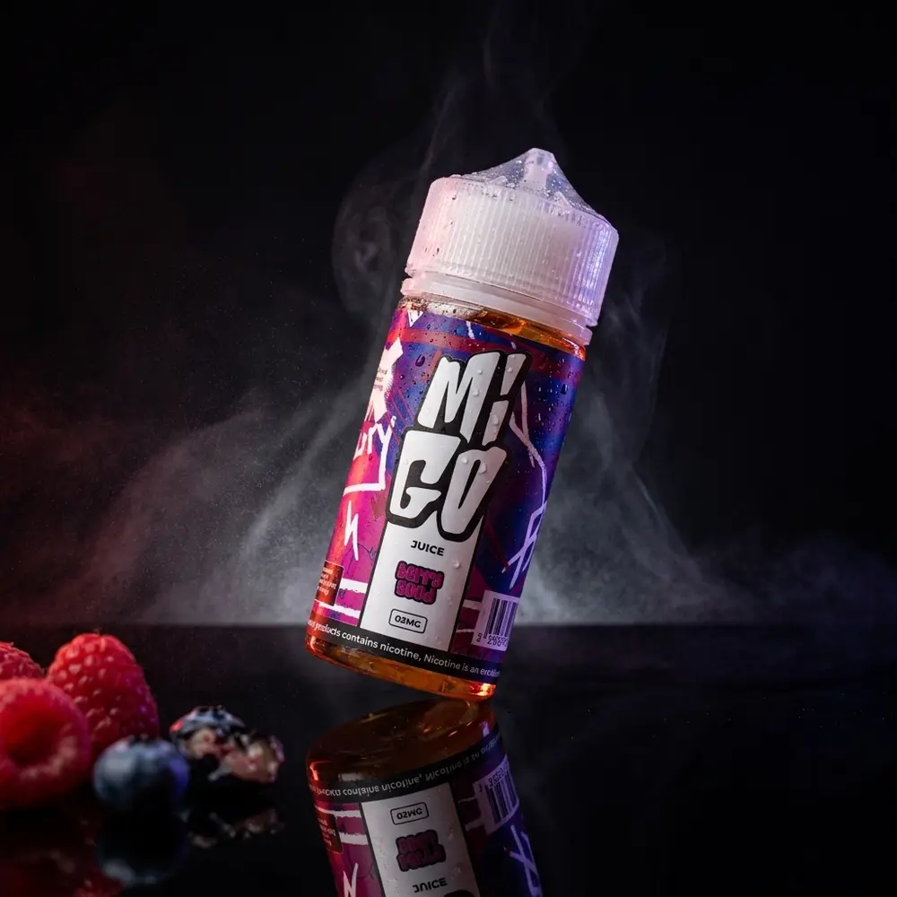 frasco de 100ml do liquido migo - berry good sobre base acrilica preta com condensacao, reflexos rubi e neblina suave - Vapor Gringo
