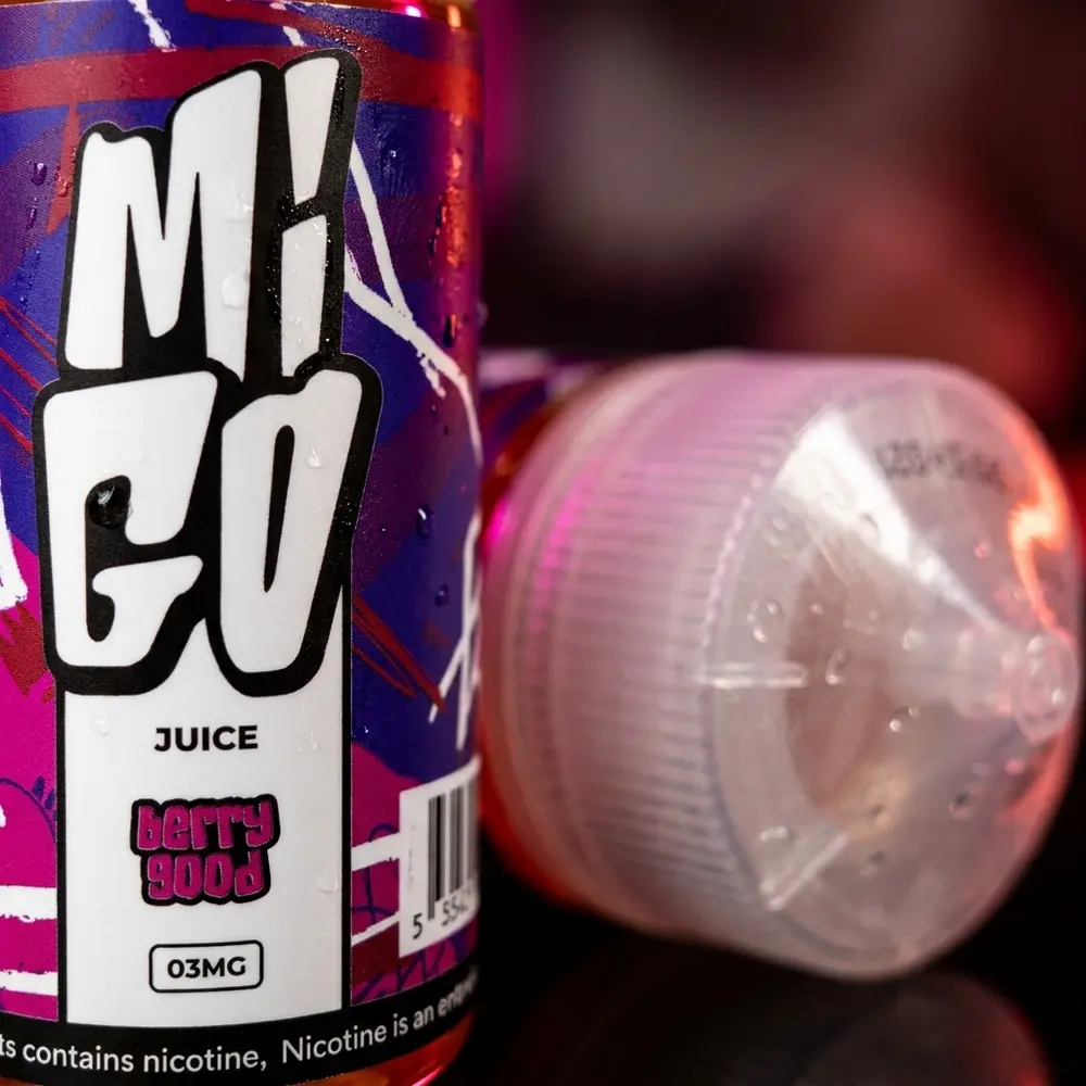 detalhe macro do rotulo e bico do liquido migo - berry good com gotas de condensacao e textura plastica realista - Vapor Gringo
