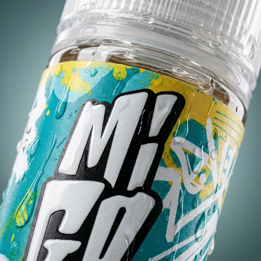 Detalhe do rótulo do Líquido Migo Gelo Tropical com gotículas de condensação e reflexos nítidos - Vapor Gringo