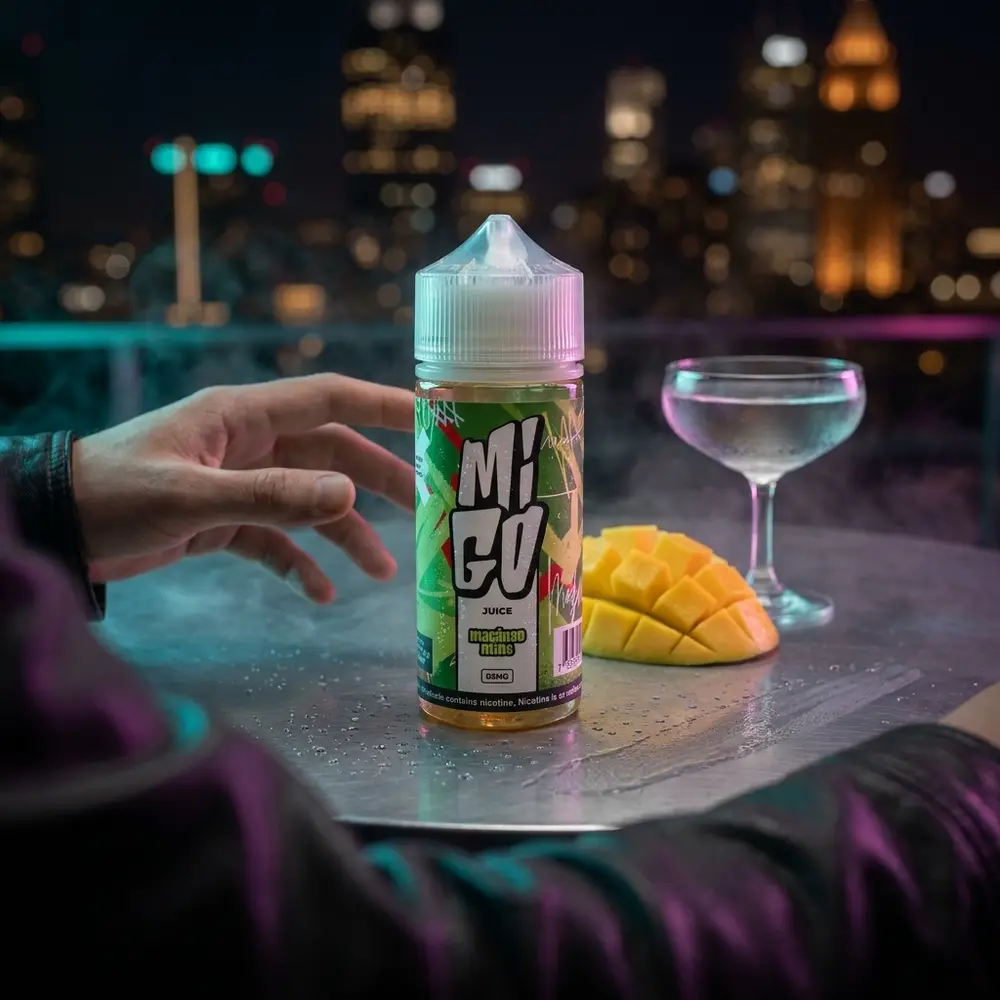 Líquido Migo Maçãngo Mint 100ml em mesa metálica num rooftop noturno com bokeh de cidade e fatia de manga - Vapor Gringo