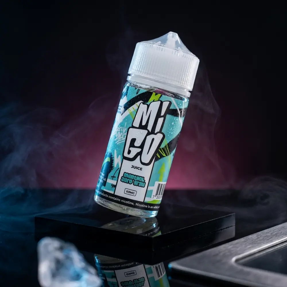 Frasco 100ml Liquido Migo Menthol Zero Grau sobre base acrilica molhada com condensacao e luzes frias em estúdio - Vapor Gringo