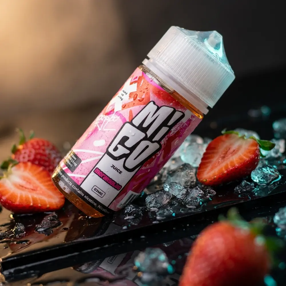 Frasco Líquido Migo Morangoloo 100ml inclinado sobre acrílico molhado com morangos e gelo ao redor - Vapor Gringo