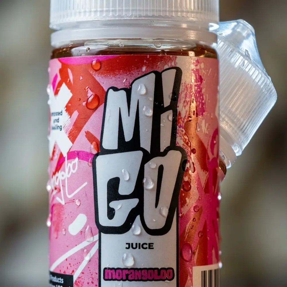Close-up do rótulo do Migo Morangoloo com gotas de condensação e textura da etiqueta visível - Vapor Gringo