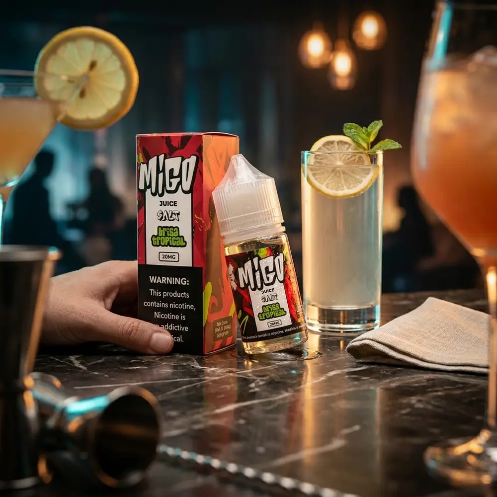 Frasco Líquido Migo Salt - Brisa Tropical sobre balcão de lounge com copo tropical ao lado e luzes quentes ao fundo - Vapor Gringo