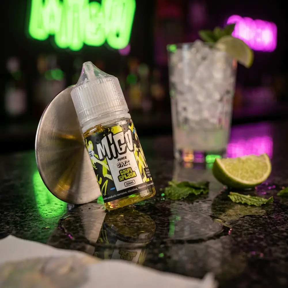 Garrafa Liquido Migo Salt Caipi Splash em balcão molhado de bar com neon verde e magenta, pedaço de limao e copo desfocado - Vapor Gringo