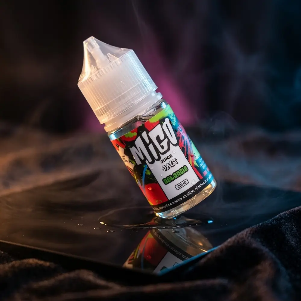 Garrafa Líquido Migo Salt Gelancia inclinada sobre acrílico preto brilhante com luzes azuis e âmbar e condensação leve - Vapor Gringo