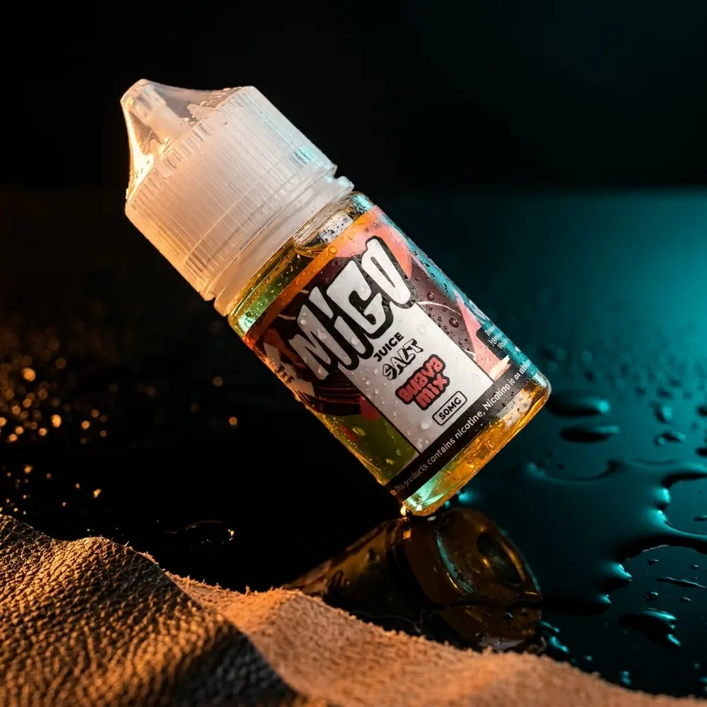 Frasco Líquido Migo Salt Melaozinho 30ml sobre acrílico preto com gotas, reflexos e luzes teal e âmbar - Vapor Gringo