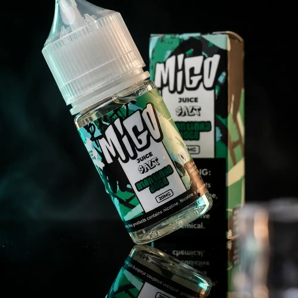 Garrafa Líquido Migo Salt Mentinha Doce sobre superfície acrílica preta com luzes mint e âmbar ambiente. - Vapor Gringo