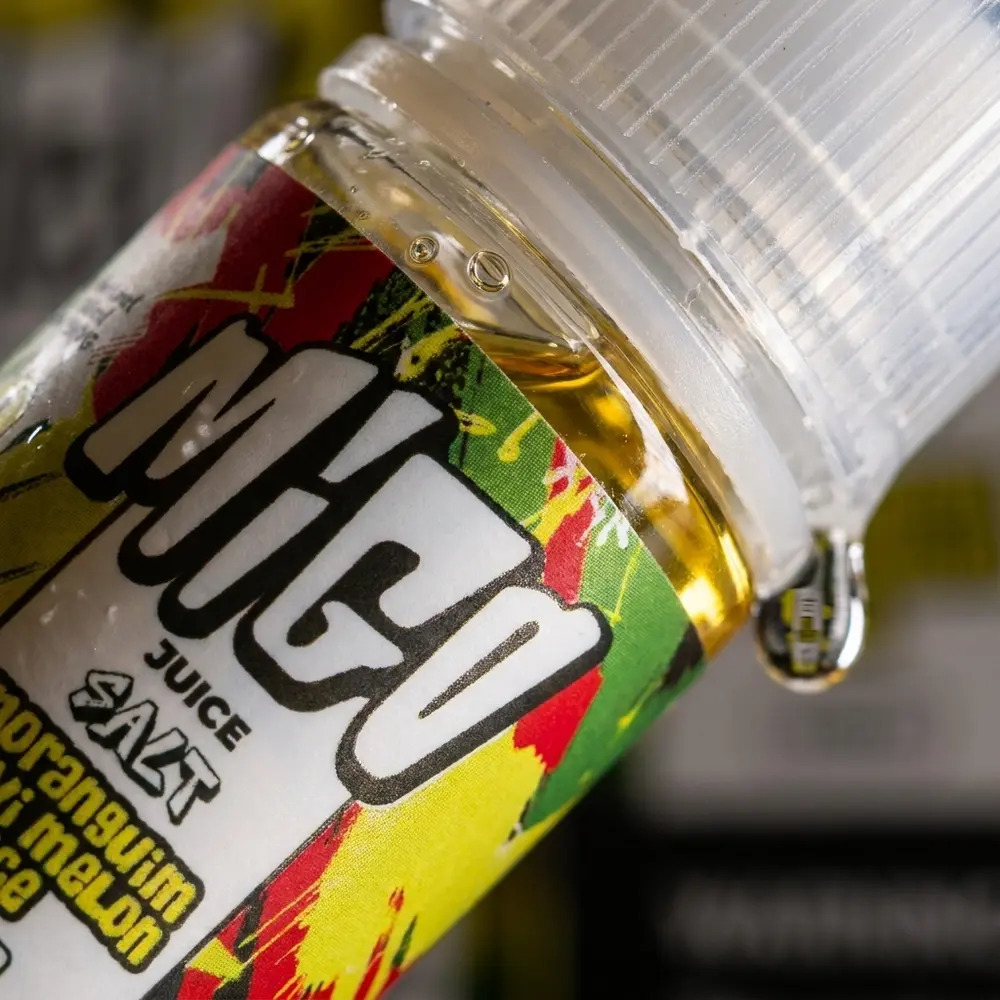 Close-up do rótulo e bico da garrafa Liquido Migo Salt Moranguim Kiwi Melon Ice com gotas e textura - Vapor Gringo