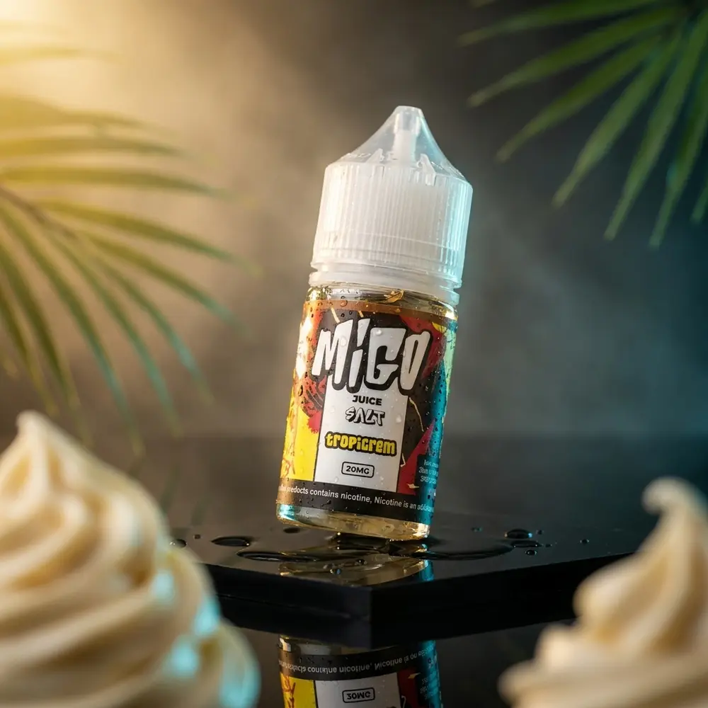 Garrafa Liquido Migo Salt Tropicrem sobre base acrilica preta com gotas, iluminacao dourada e ciano - Vapor Gringo
