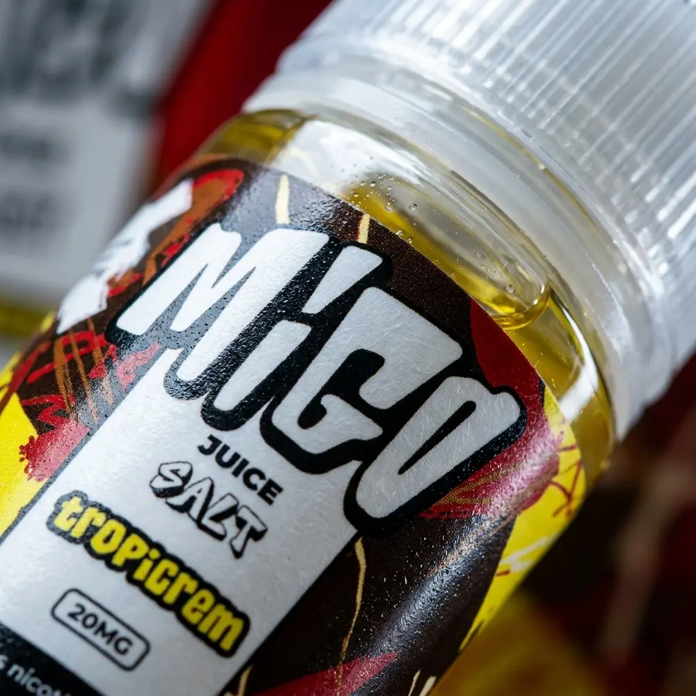Detalhe do rótulo Líquido Migo Salt Tropicrem com condensação, textura do plástico e reflexos precisos - Vapor Gringo