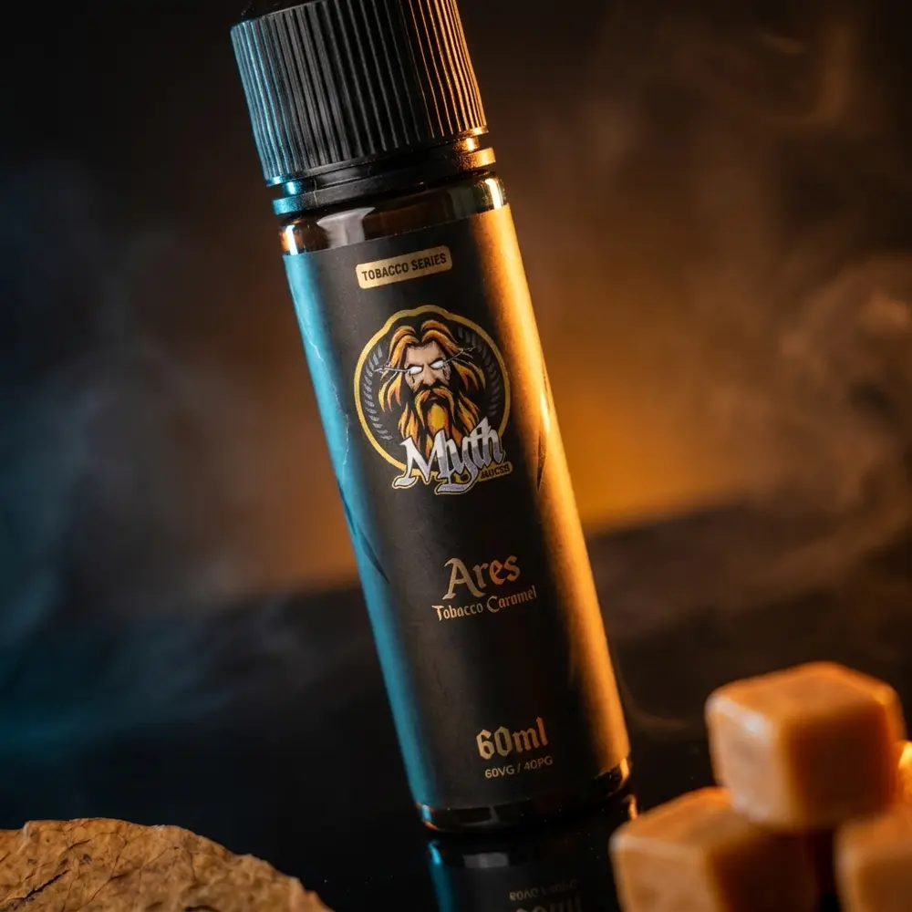 Garrafa Líquido Myth Ares Tobacco Caramel em estúdio sobre acrílico, iluminação âmbar e elementos de caramelo - Vapor Gringo