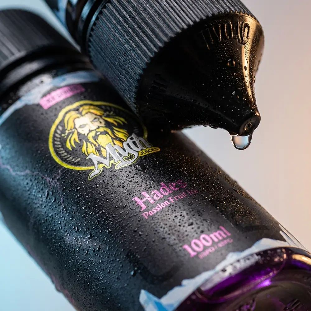 Close-up do rótulo e bico do Líquido Myth Hades Passion Fruit Ice 100ml com microgotas e uma gota pendente - Vapor Gringo