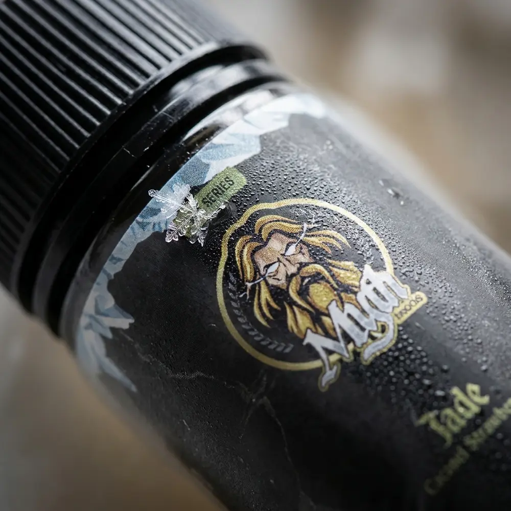 Close-up do rótulo e bico do Líquido Myth Jade 100ml com gotículas de condensação e reflexos metálicos - Vapor Gringo