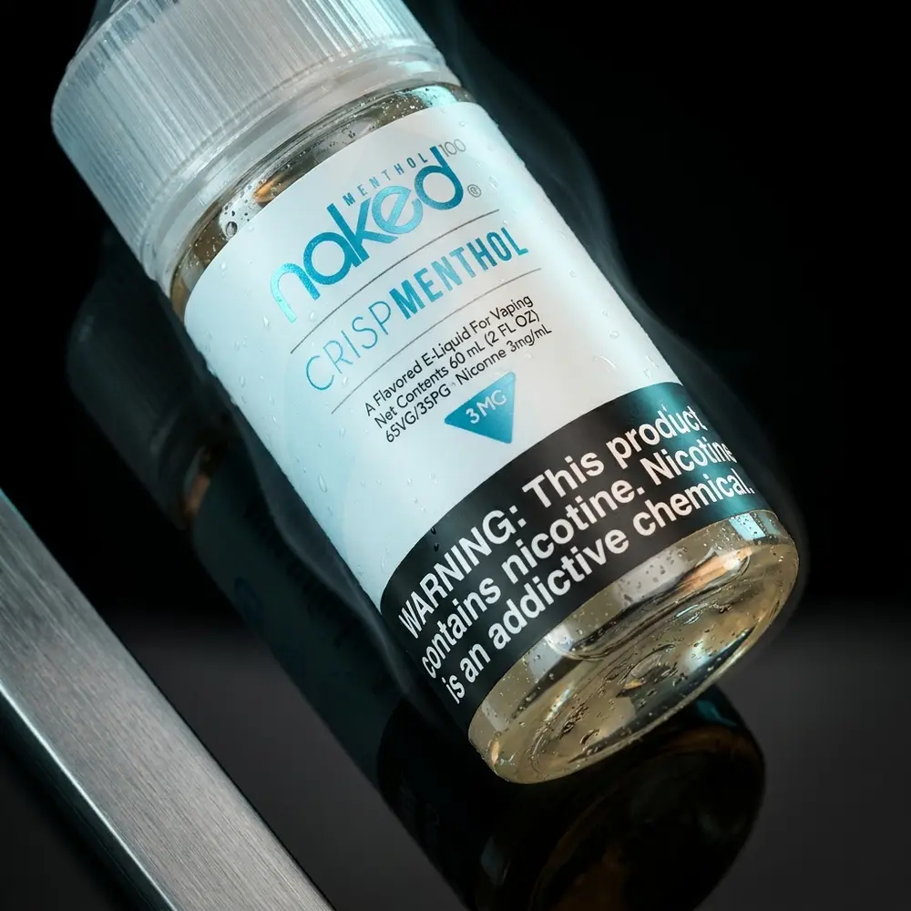 Frasco de líquido Naked 100 Crisp Menthol 60ml sobre base acrílica preta com condensação e luzes frias - Vapor Gringo