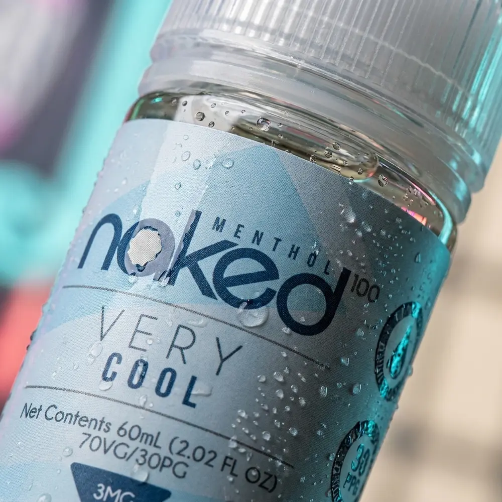 Close-up do rotulo e bico do liquido Naked 100 Very Cool, condensacao, textura do vidro e reflexos finos - Vapor Gringo