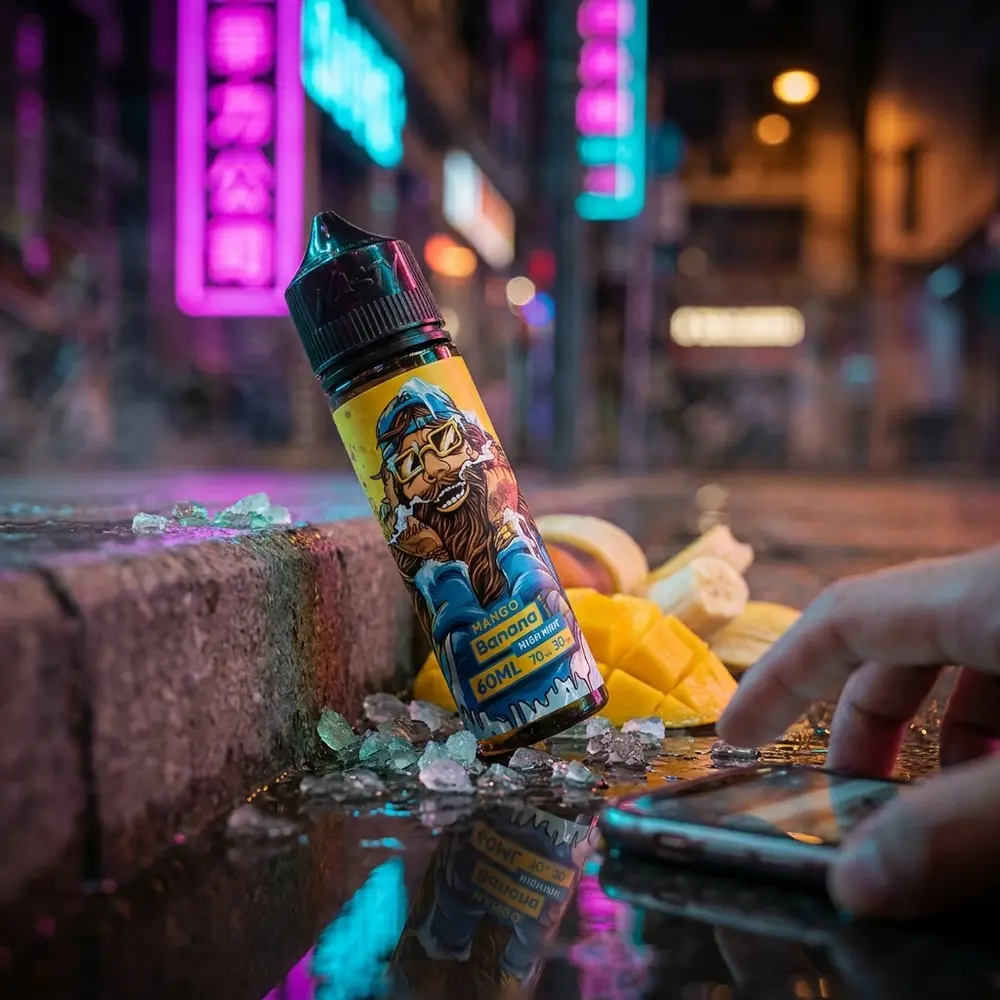 Garrafa Nasty Juice Cush Man Mango Banana apoiada em beirada de concreto molhado com néon urbano, manga e gelo mentolado - Vapor Gringo