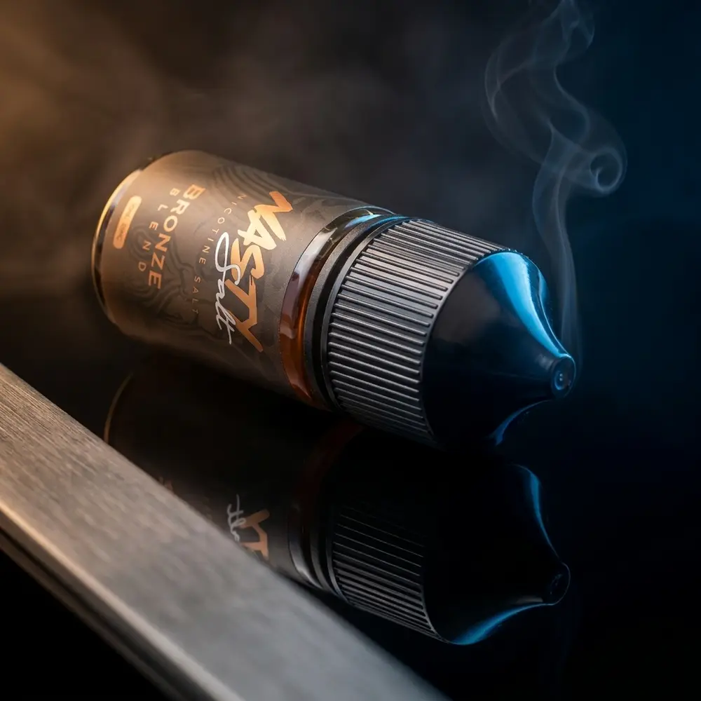 Frasco Nasty Juice Salt Bronze Blend em close sobre acrílico preto, luz caramelo e azul, rótulo nítido - Vapor Gringo