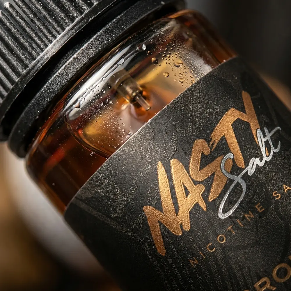 Detalhe macro do rótulo Nasty Juice Salt Bronze Blend, gotas de condensação e textura da tampa metálica - Vapor Gringo