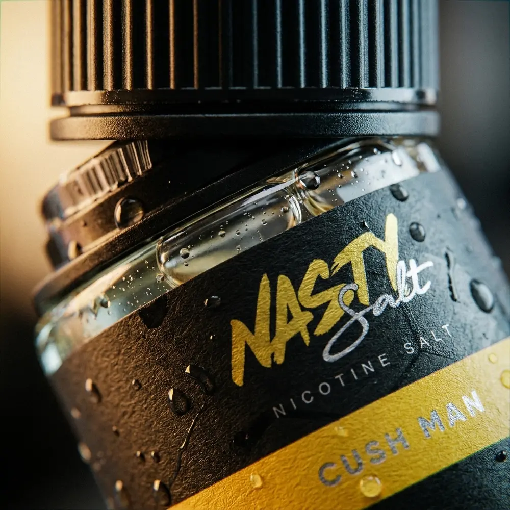 Detalhe do rotulo e bico da garrafa Nasty Juice Salt Cush Man com gotas de condensacao e textura do vidro. - Vapor Gringo