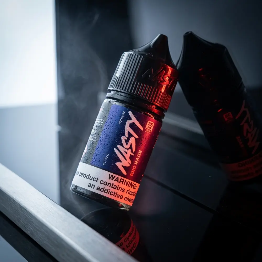 Garrafa Líquido Nasty Juice Salt Red Rage 30ml sobre acrílico preto com luzes dramáticas e condensação - Vapor Gringo