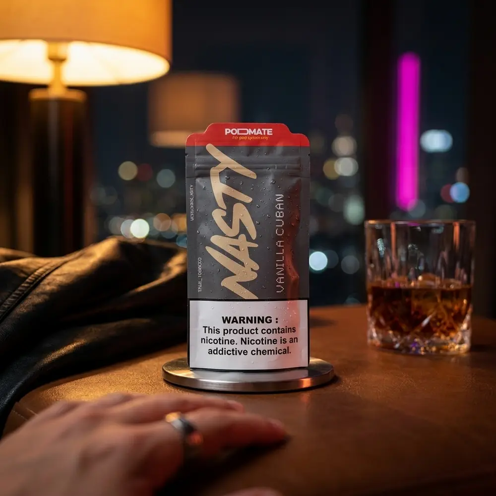 Garrafa Nasty Juice Vanilla Cuban 30ml em lounge noturno sobre bandeja metálica, copo de rum e luzes neon ao fundo - Vapor Gringo