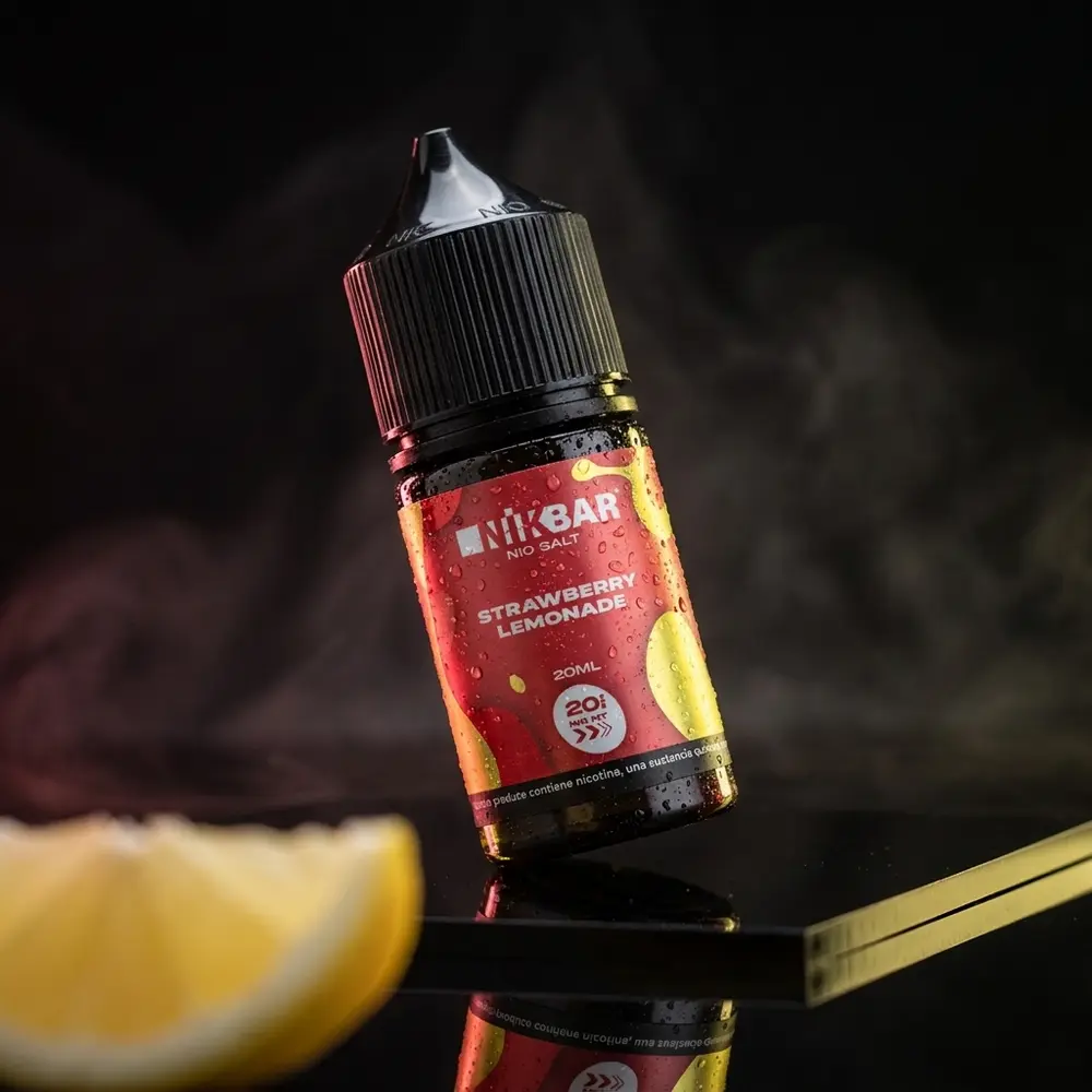 Garrafa Liquido Nikbar Salt Strawberry Lemonade sobre acrilico preto com iluminacao rosa e amarela e gotas de condensacao - Vapor Gringo